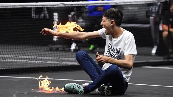 epaselect epa10201633 A climate change activist protests against UK private jets while lighting his right arm on fire during the Laver Cup tennis tournament at the O2 Arena in London, Britain, 23 September 2022.  EPA/ANDY RAIN