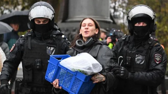 Police officers detain a woman in Moscow on September 24, 2022, following calls to protest against the partial mobilisation announced by the Russian President. - President Vladimir Putin called up Russian military reservists on September 21, 2022, saying his promise to use all military means in Ukraine was "no bluff," and hinting that Moscow was prepared to use nuclear weapons. His mobilisation call comes as Moscow-held regions of Ukraine prepare to hold annexation referendums this week, dramatically upping the stakes in the seven-month conflict by allowing Moscow to accuse Ukraine of attacking Russian territory. (Photo by AFP)