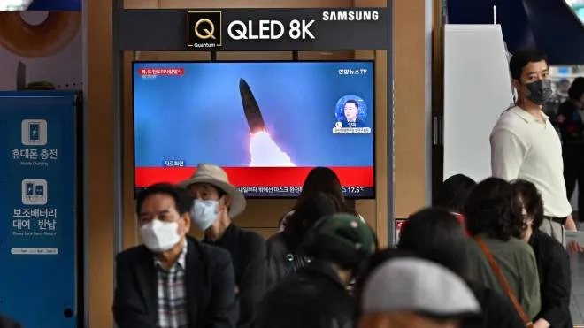 People watch a television screen showing a news broadcast with file footage of a North Korean missile test, at a railway station in Seoul on September 25, 2022. - North Korea fired a ballistic missile on September 25, Seoul's military said, just days after a US aircraft carrier arrived for joint drills with the South in a show of force against Pyongyang. (Photo by Jung Yeon-je / AFP)