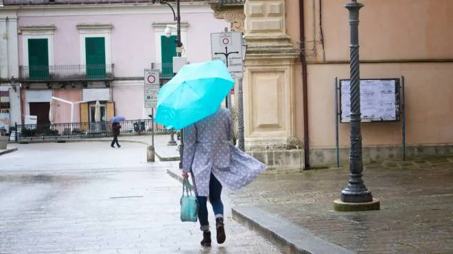 Sicily: Rainy Day in 18-Century Baroque Town; Woman  with Matching Turquoise Umbrella and Bag Walking on Cobbled Street