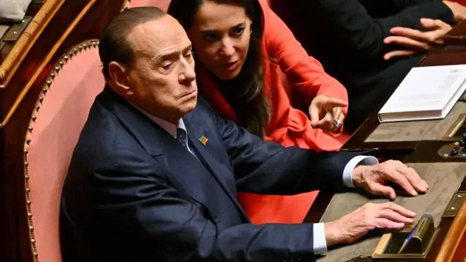 Leader of the Italian right-wing party "Forza Italia" (FI), Silvio Berlusconi (L) sits next to Forza Italia member Licia Ronzulli, during the vote for the new president of the Senate following the general elections, on October 13, 2022. - Italian Senators and Deputies meet for the first time October 13, 2022, since elections to elect the new Presidents of the Parliament and the Senate. (Photo by Andreas SOLARO / AFP)