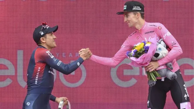 A destra l’australiano Jai Hindley, vincitore del Giro d’Italia 2022, con il secondo classificato, l’ecuadoregno Richard Antonio Carapaz a sinistra, sul podio finale: quest’anno la corsa rosa si concluderà a Roma dopo la partenza dall’Abruzzo