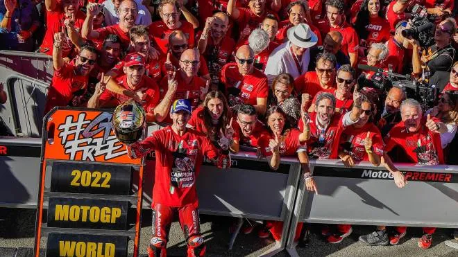 Il 2022 è stato l’anno della Ducati su tutti i fronti: a sinistra la gioia della squadra della Motogp che ha vinto il mondiale costruttori e quello piloti con Pecco Bagnaia, a destra il team Superbike con Bautista