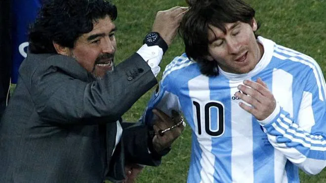 Leo Messi con Diego Maradona, a sinistra un murales che li ritrae a Buenos Aires