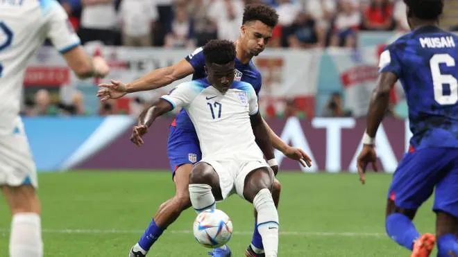 epa10328711 Bukayo Saka (front) of England in action against Antonee Robinson of the US during the FIFA World Cup 2022 group B soccer match between England and the USA at Al Bayt Stadium in Al Khor, Qatar, 25 November 2022.  EPA/Ali Haider