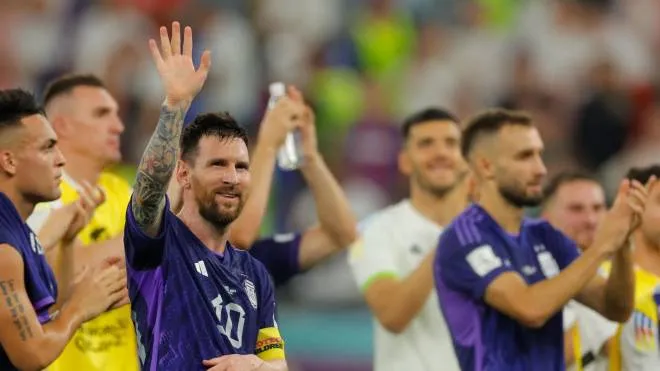 TOPSHOT - Argentina's forward #10 Lionel Messi (L) waves to supporters after his team won the Qatar 2022 World Cup Group C football match between Poland and Argentina at Stadium 974 in Doha on November 30, 2022. (Photo by Odd ANDERSEN / AFP)