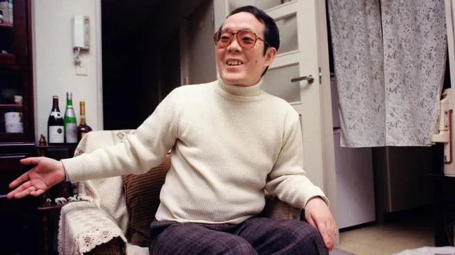 (FILES) This file photo taken on February 5, 1992 shows former Japanese student Issei Sagawa, known as the "Kobe Cannibal" for killing and then devouring a Dutch student in 1981, smiling and gesturing as he meets with an AFP journalist at his apartment in Yokohama. - Sagawa died at the age of 73 on November 24, 2022 his friend and brother said in a statement on December 2. (Photo by JUNJI KUROKAWA / AFP)