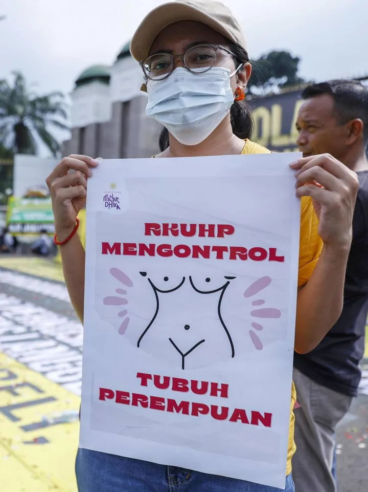 Una manifestante protesta contro la legge approvata in Indonesia che vieta i rapporti sessuali alle coppie non sposate