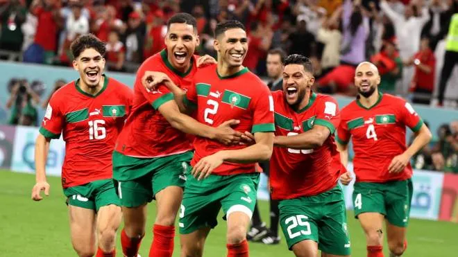 epa10352428 Players of Morocco celebrate with Achraf Hakimi (C) after he scored the last penalty kick which sent Morocco to the quarter final during the FIFA World Cup 2022 round of 16 soccer match between Morocco and Spain at Education City Stadium in Doha, Qatar, 06 December 2022.  EPA/Mohamed Messara
