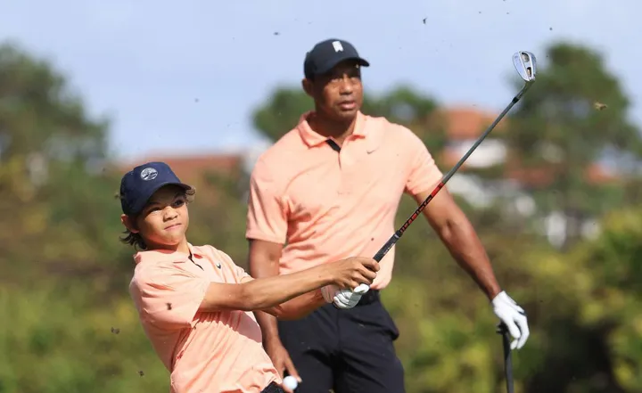 Da sinistra, Charlie e Tiger Woods in azione su un campo da golf: padre e figlio si ritrovanno nuovamente insieme nella sfida tra coppie di parenti in Florida