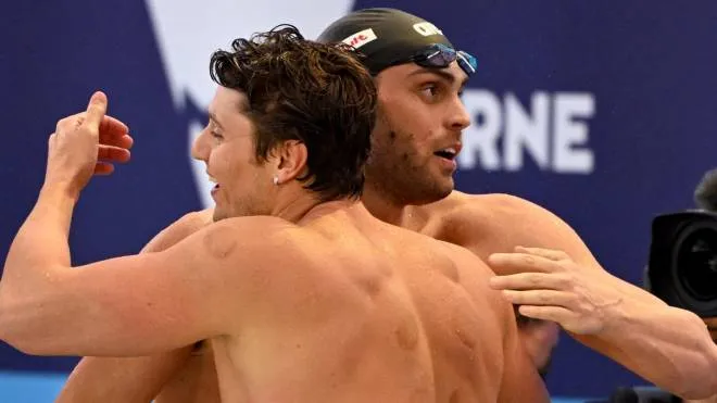 Matteo Rivolta of Italy (R) celebrates with teammates after winning gold in the Men's 4x50m Medley Relay final at the FINA World Swimming Championships (25m) 2022 in Melbourne on December 17, 2022. (Photo by William WEST / AFP) / --IMAGE RESTRICTED TO EDITORIAL USE - NO COMMERCIAL USE--