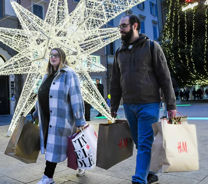 Un momento di shopping natalizio tra gli addobbi di strada, in centro a Modena