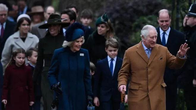 Britain's King Charles III (R) flanked by Britain's Camilla, Queen Consort (L) waves to members of the public as he arrives for the Royal Family's traditional Christmas Day service at St Mary Magdalene Church in Sandringham, Norfolk, eastern England, on December 25, 2022. (Photo by Daniel LEAL / AFP)