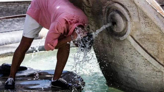 Turisti si rinfrescano per il caldo nella fontana di piazza di Spagna per il Ferragosto durante la Fase 3 dell�emergenza per il Covid-19 Coronavirus, Roma, 15 agosto 2020. ANSA/ANGELO CARCONI