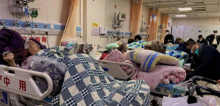 Pazienti ammassati in un reparto Covid dell’ospedale Tangshan Gongren nella città nord-orientale cinese di Tangshan; con i malati ci sono anche i famigliari