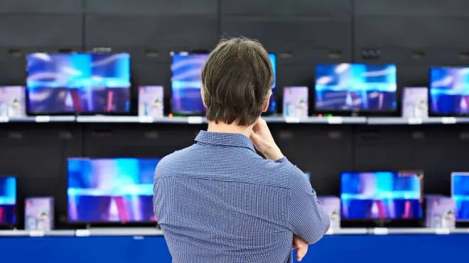 Man looks at LCD TVs in supermarket