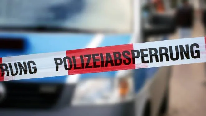 Police cordon tape with a police car in the background (Germany)