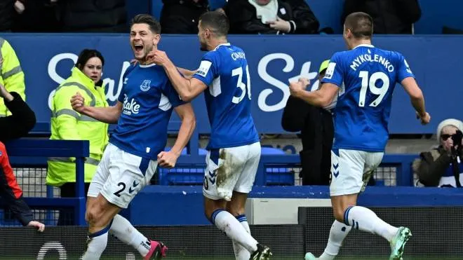 Everton's English defender James Tarkowski (L) celebrates with teammates after scoring a goal during the English Premier League football match between Everton and Arsenal at Goodison Park in Liverpool, north-west England, on February 4, 2023. (Photo by Paul ELLIS / AFP) / RESTRICTED TO EDITORIAL USE. No use with unauthorized audio, video, data, fixture lists, club/league logos or 'live' services. Online in-match use limited to 120 images. An additional 40 images may be used in extra time. No video emulation. Social media in-match use limited to 120 images. An additional 40 images may be used in extra time. No use in betting publications, games or single club/league/player publications. /