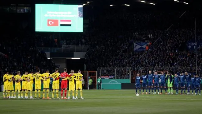 epa10455489 Players of VfL Bochum and Borussia Dortmund line up during a minute of silence to pay respect to the victims of the catastrophic earthquake that hit Turkey and Syria prior to the German DFB Cup Round of 16 soccer match between VfL Bochum and Borussia Dortmund in Bochum, Germany, 08 February 2023.  EPA/FRIEDEMANN VOGEL