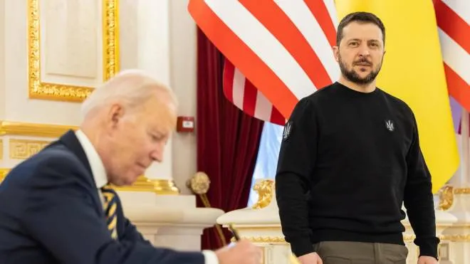 A sinistra: Biden firma il libro degli ospiti nel palazzo presidenziale sotto lo sguardo di Zelensky