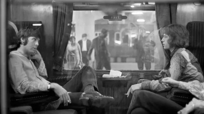 Paul McCartney, 80 anni, e Mick Jagger, 79, nel 1967 sul vagone di un treno fermo nella stazione di Bangor, in Galles
