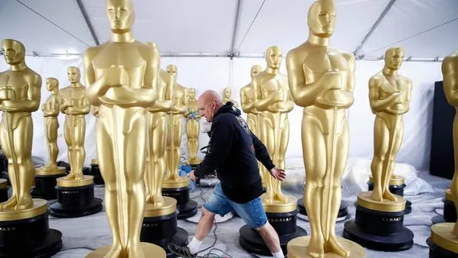 epa10514261 Rick Roberts walks through an area with various Oscar statues as they are worked on as preparations for the 95th annual Academy Awards ceremony get underway in Los Angeles, California, USA, 10 March 2023.  EPA/CAROLINE BREHMAN