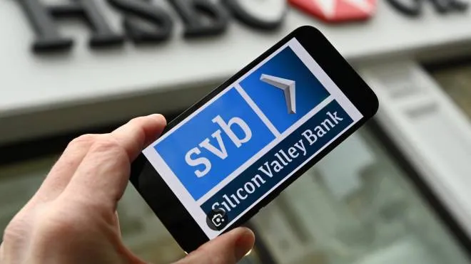 epa10519745 An SVB logo is shown on a smartphone outside a HSBC bank branch in London, Britain, 13 March 2023. The HSBC Holdings financial services company has announced it has bought SVB (Silicon Valley Bank) for one British Pound (�1). The deal protects depositors assets and prevents the US bank's UK operations from collapse.  EPA/ANDY RAIN