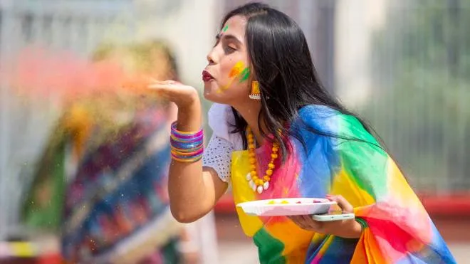 epa10507024 A Hindu devotee blows colored powder during celebrations for the Holi Festival at the Dhakeshwari National Temple in Dhaka, Bangladesh, 07 March 2023. Holi is celebrated on the full moon day in the Hindu month of Phalguna and heralds the onset of spring season.  EPA/MONIRUL ALAM