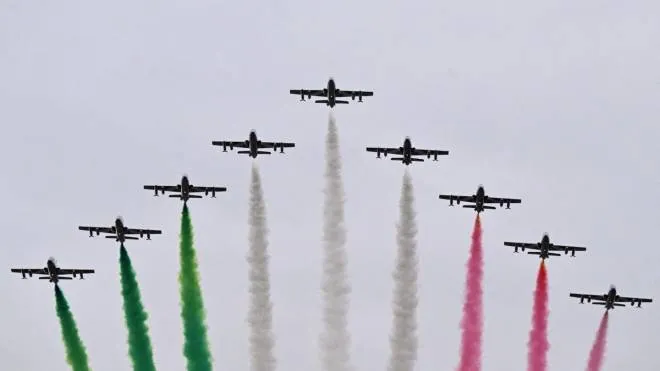 Planes of the Frecce Tricolori aerobatics unit perform overhead as participants take the start of the Rome Marathon on Via dei Fori Imperiali by the Colosseum monument (Rear) on March 19, 2023 in Rome. (Photo by Tiziana FABI / AFP)