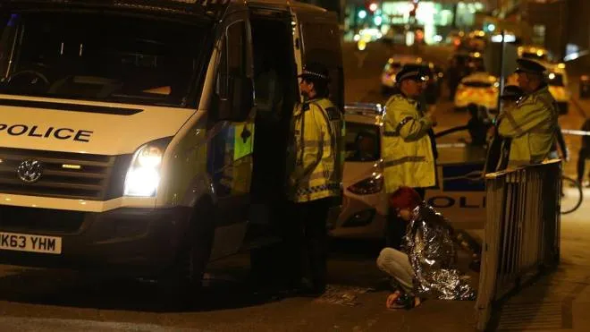 epa05982571 A woman sits in the street in a blanket near the Manchester Arena as police guard the area following reports of an explosion, in Manchester, Britain, 23 May 2017. According to a statement released by the Greater Manchester Police on 23 May 2017, police responded to reports of an explosion at Manchester Arena on 22 May 2017 evening. At least 19 people have been confirmed dead and others 50 were injured, authorities said. The happening is currently treated as a terrorist incident until police know otherwise. According to reports quoting witnesses, a mass evacuation was prompted after explosions were heard at the end of US singer Ariana Grande's concert in the arena.  EPA/NIGEL RODDIS