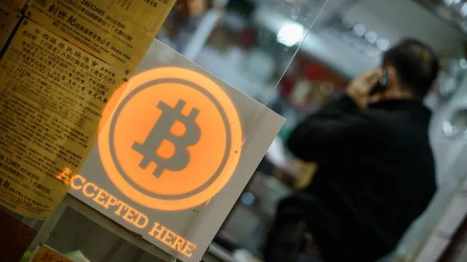 (FILES) This file picture taken on February 28, 2014 shows a man talking on a mobile phone in a shop displaying a bitcoin sign during the opening ceremony of the first bitcoin retail shop in Hong Kong.  
Chinese bitcoin investors found themselves dismayed and hopeless, after the country's regulators have ordered local cryptocurrency exchanges to shut down, in the latest blow to the once flourishing Chinese market for virtual money even as the Asian giant remains home to the "mining" (creation) of most part of newly coined bitcoins. / AFP PHOTO / PHILIPPE LOPEZ / RESTRICTED TO EDITORIAL USE - MANDATORY MENTION OF THE ARTIST UPON PUBLICATION - TO ILLUSTRATE THE EVENT AS SPECIFIED IN THE CAPTION