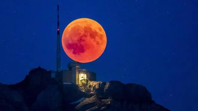 epa06914725 The blood moon rises behind the Saentis (2502m) Alpstein, Canton of Appenzell, Switzerland, 27 jukly 2018, on the night of the longest total lunar eclipse of the 21st century.  EPA/CHRISTIAN MERZ