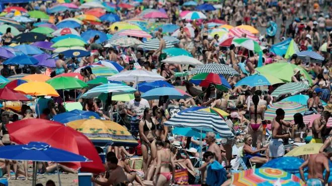 epa06915940 People enjoy the warm temperatures at a beach in Valencia, eastern Spain, 28 July 2018, on a day when high temperatures were reached.  EPA/Kai Forsterling
