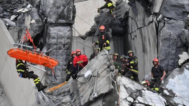 Rescuers recover an injured person after a highway bridge collapsed in Genoa, Italy, 14 August 2018. A large section of the Morandi viaduct upon which the A10 motorway runs collapsed in Genoa on Tuesday. Several people have died, rescue sources said. Several vehicles were crushed under the rubble with dead people inside, the sources said. ANSA/ LUCA ZENNARO