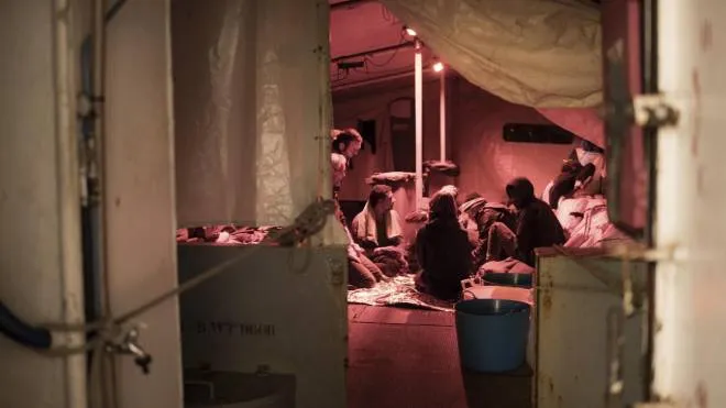 In this picture taken Monday, Dec. 24, 2018, migrants sit aboard of the rescue ship Sea-Watch 3. Thirty tree migrants saved in the central Mediterranean sea by the German no-profit rescue organization Sea-Watch are still stranded after five days at sea, because no European country is opening its ports to receive them. (Chris Grodotzki/Sea Watch Via AP) [CopyrightNotice: Chris Grodotzki / jib collective for Sea-Watch]