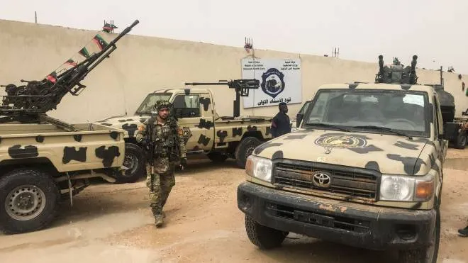 Local militamen, belonging to a group opposed to Libyan strongman Khalifa Haftar, stand next to vehicles the group said they seized from Haftar's forces at one of their bases in the coastal town of Zawiya, west of Tripoli on April 5, 2019, hours after Haftar's froces were pushed back from a key checkpoint less than 30 kilometres (18 miles) from Tripoli, according to security source said. - The militiamen retook the base after a &quot;short exchange of fire&quot;, the source said April 5 on condition of anonymity. The Zawiya militia is one of dozens that have proliferated since the overthrow of veteran dictator Moamer Kadhafi in a NATO-backed uprising in 2011 and are variously aligned with the UN-backed unity government in the capital and a rival administration in the east backed by Haftar's forces. (Photo by Mahmud TURKIA / AFP)