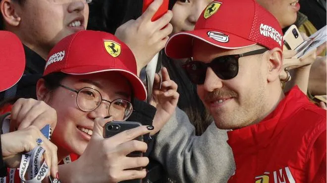 Ferrari driver Sebastian Vettel of Germany poses a selfie with a Chinese woman during an autograph session at the Shanghai International Circuit ahead of the Chinese Formula One Grand Prix in Shanghai, China, Thursday, April 11, 2019. (ANSA/AP Photo/Andy Wong) [CopyrightNotice: Copyright 2018 The Associated Press. All rights reserved]