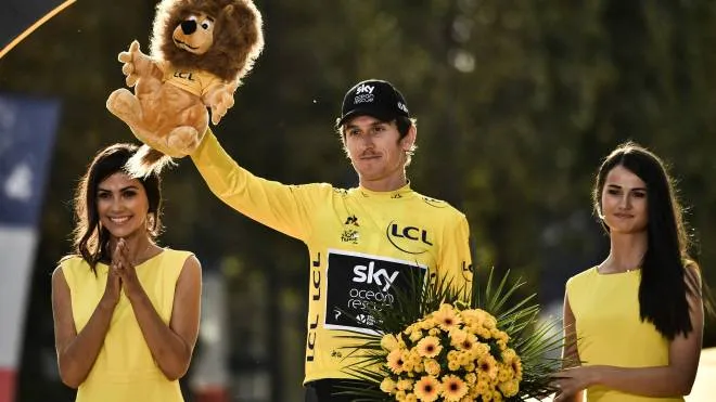 Tour de France 2018 winner Great Britain's Geraint Thomas (C) celebrates his overall leader yellow jersey on the podium after the 21st and last stage of the 105th edition of the Tour de France cycling race between Houilles and Paris Champs-Elysees, on July 29, 2018. / AFP PHOTO / Marco BERTORELLO