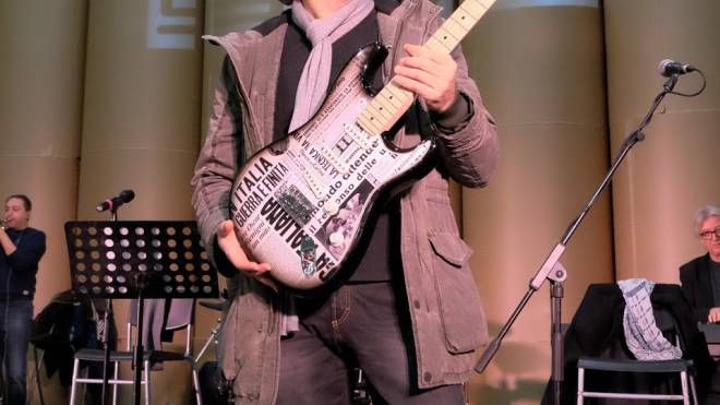 Andrea Fornili e la chitarra con stampati i titoli del Carlino (fotoSchicchi)
