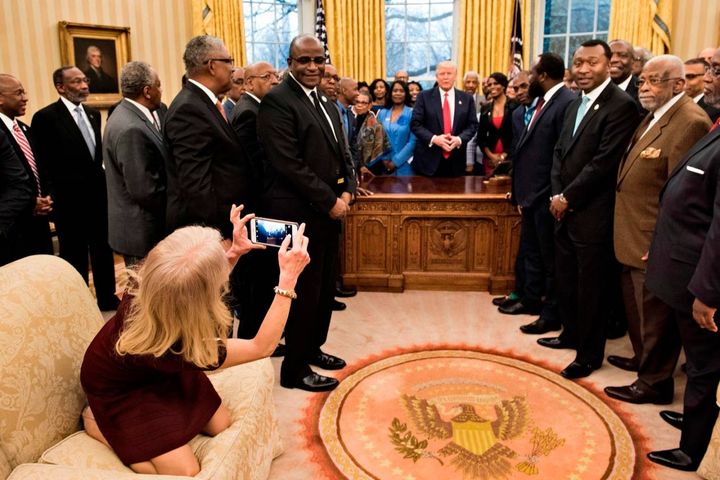 La consigliera di Trump Kellyanne Conway scatta una foto in ginocchio sul divano dello Studio Ovale, 27 febbraio 2017 (Afp, Brendan Smialowski) 