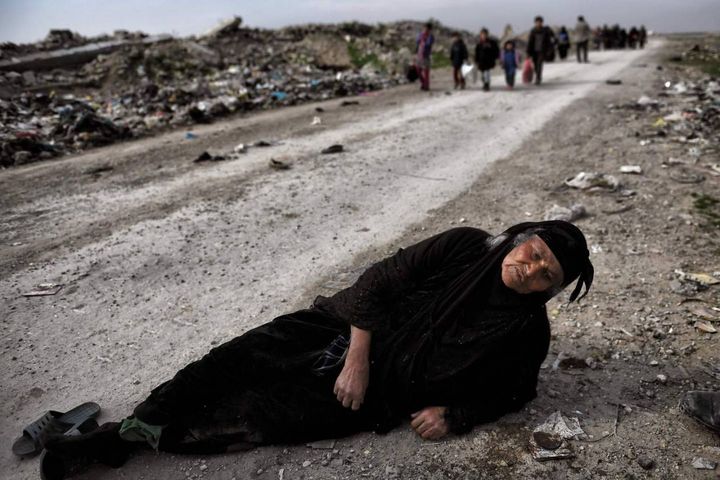 Una donna anziana a terra mentre i civili fuggono da Mosul, durante l'avanzata delle forze irachene contro l'Isis, 8 marzo 2017 (Afp, Aris Messinis)
