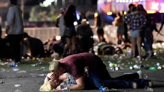 Las Vegas, un giovane protegge una ragazza durante la sparatoria al festival musicale Route 91, 1 ottobre 2017 (Afp, David Becker)