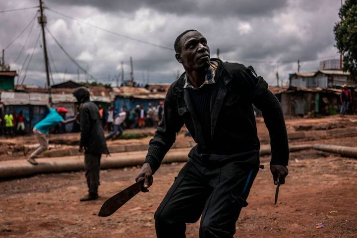 Proteste in Kenya durante le elezioni: un manifestante brandisce un machete e un coltello durante gli scontri con le forze di polizia a Kibera, Nairobi. 26 ottobre 2017 (Afp, Marco Longari)