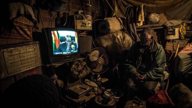 Zimbabwe, un uomo guarda il discorso del presidente Mugabe in tv, 19 novembre 2017 (Afp,  Zinyange Auntony)