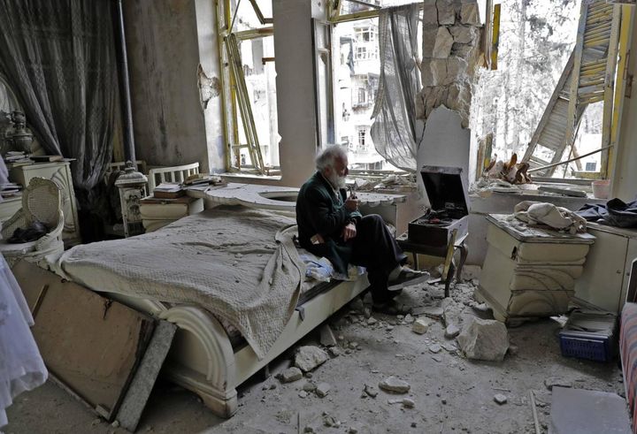 Aleppo, anziano seduto tra le macerie di casa con il grammofono (Afp, Joseph Eid)