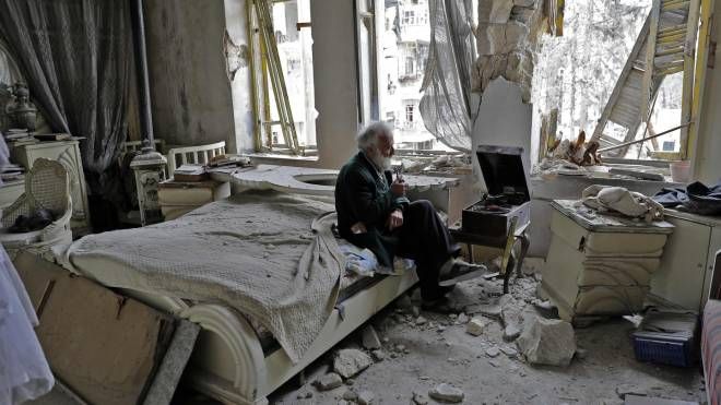 Aleppo, anziano seduto tra le macerie di casa con il grammofono (Afp, Joseph Eid)