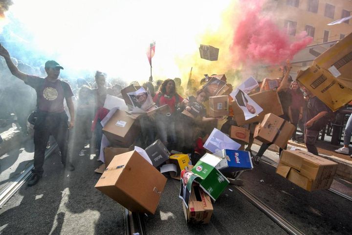 Roma, gli studenti abbattono il muro con i volti dei ministri e del premier (Ansa)