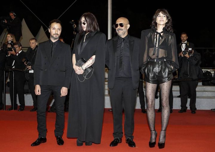 Lo stilista Anthony Vaccarello (primo a sinistra) e Charlotte Gainsbourg (ultima a destra) con uno dei suoi mini abiti Saint Laurent (Ansa)