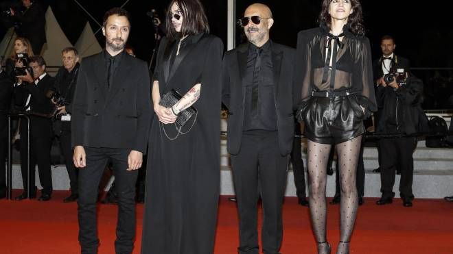 Lo stilista Anthony Vaccarello (primo a sinistra) e Charlotte Gainsbourg (ultima a destra) con uno dei suoi mini abiti Saint Laurent (Ansa)