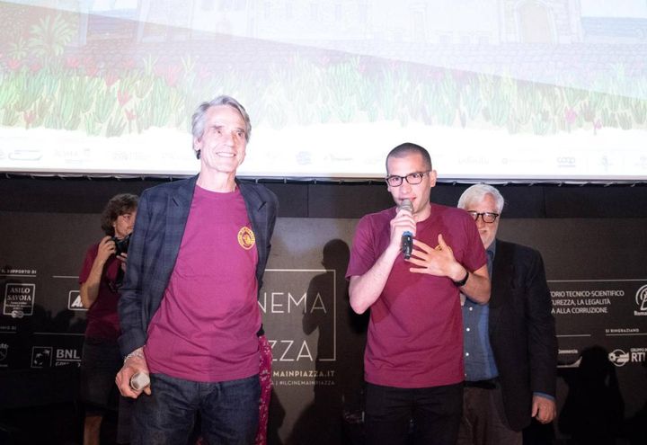 Jeremy Irons con la maglietta del cinema America per esprimere solidarietà ai ragazzi picchiati (Ansa)
